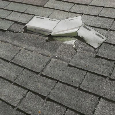 Missing shingles on an asphalt roof exposing underlayment