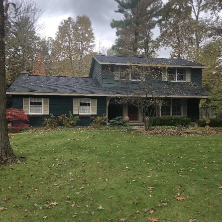 A two story residential home in Michigan with a new roof installed by Moore and Sons Roofing
