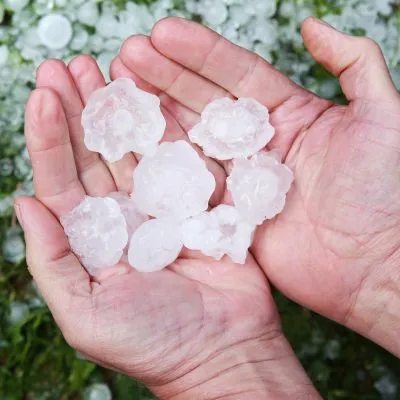 Large hailstones in outstretched hands