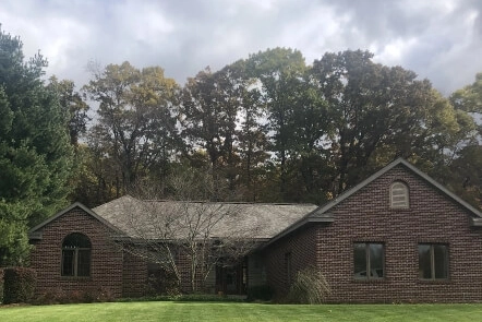 A brown ranch style home with a new roof installed by Moore and Sons Roofing in Michigan.